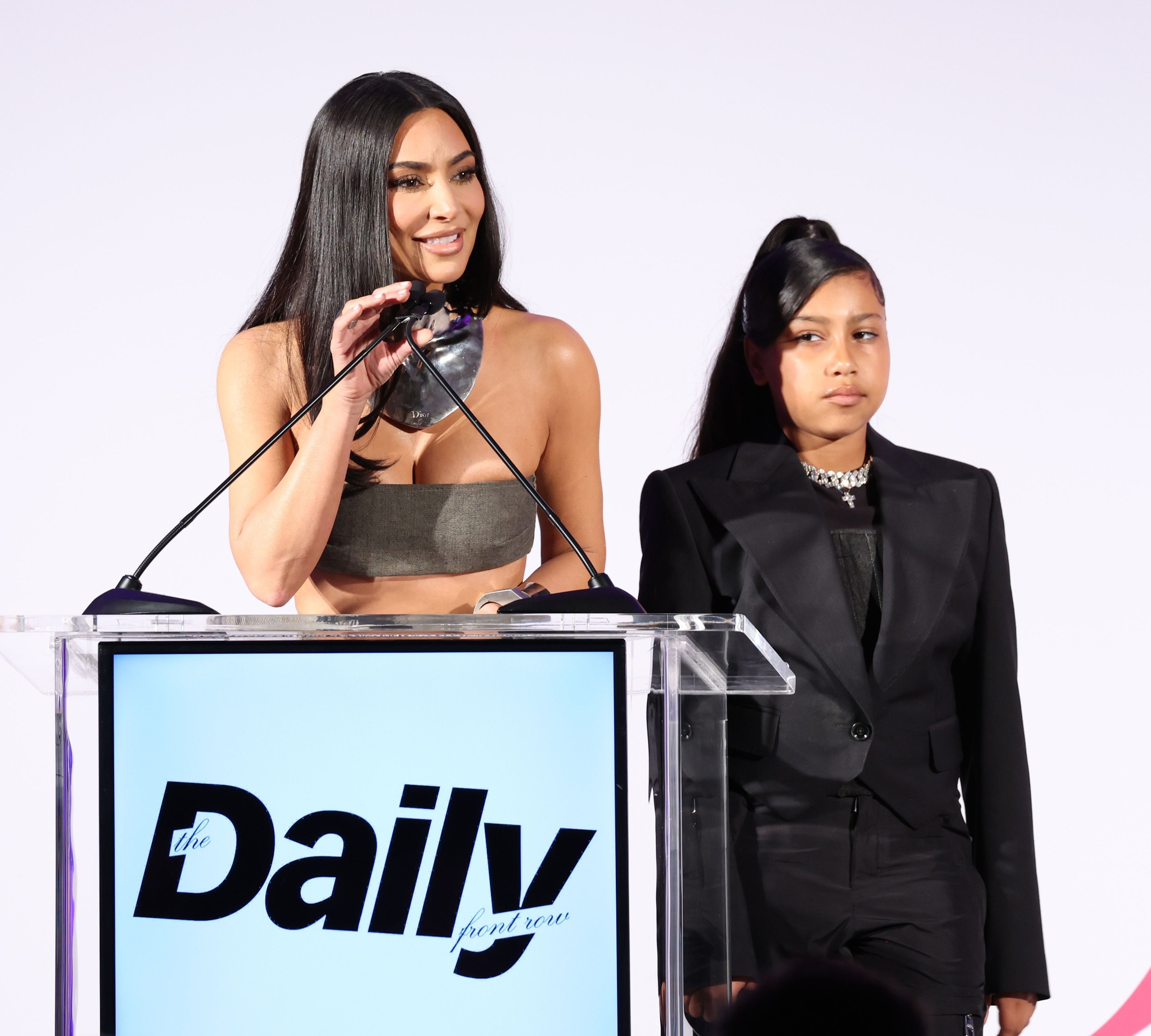 Kim Kardashian and North West stand behind a podium at an event