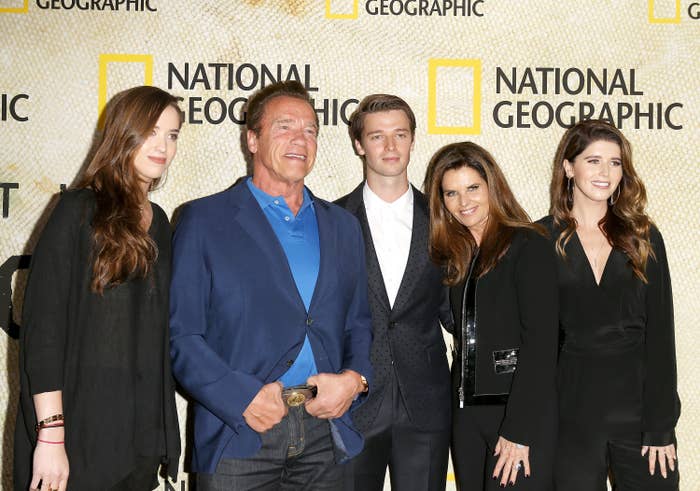 Group of five people pose on a red carpet, wearing formal attire, in front of a National Geographic backdrop