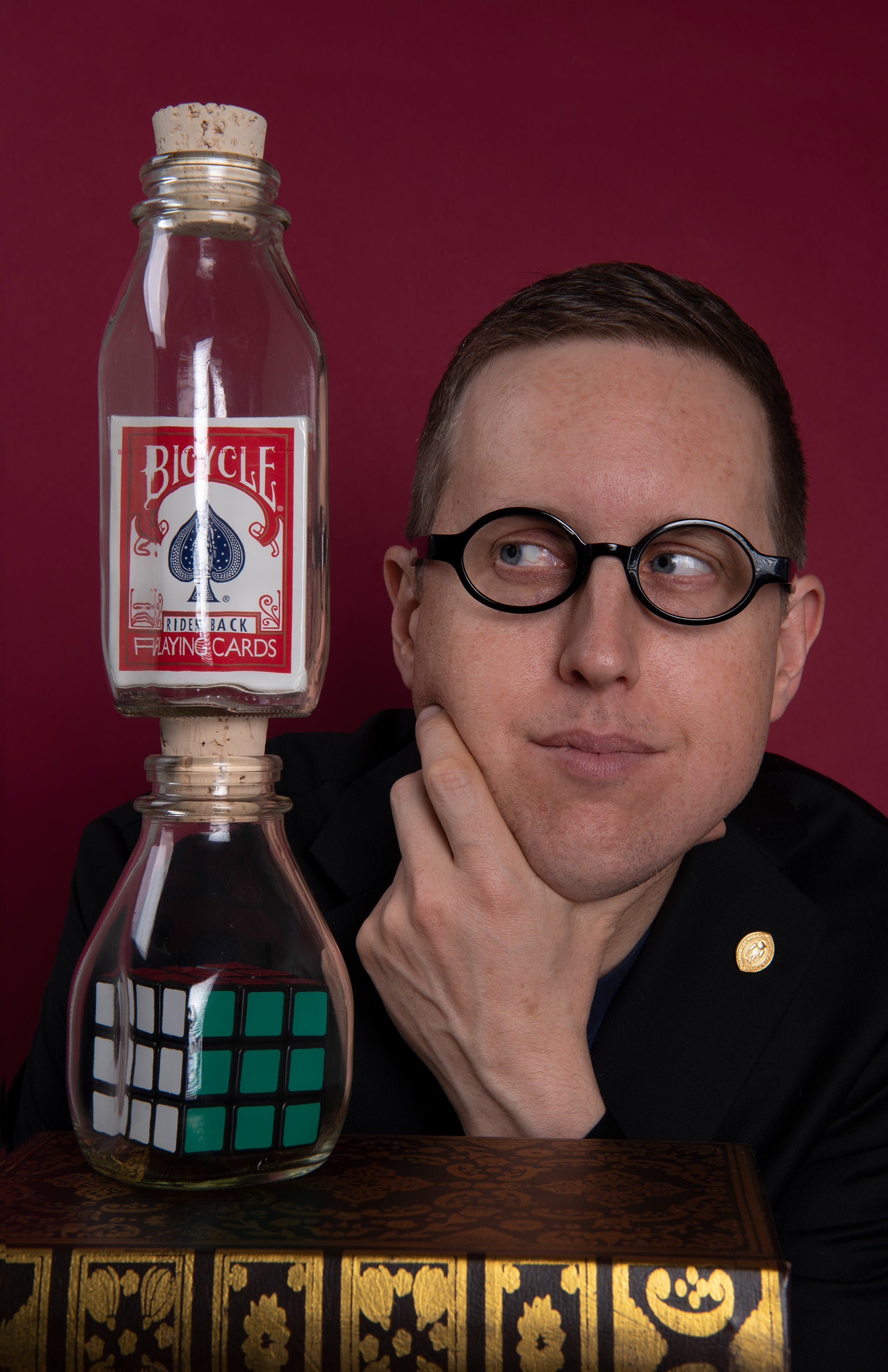 framed card deck and Rubik's cube in glass bottles on a decorative box