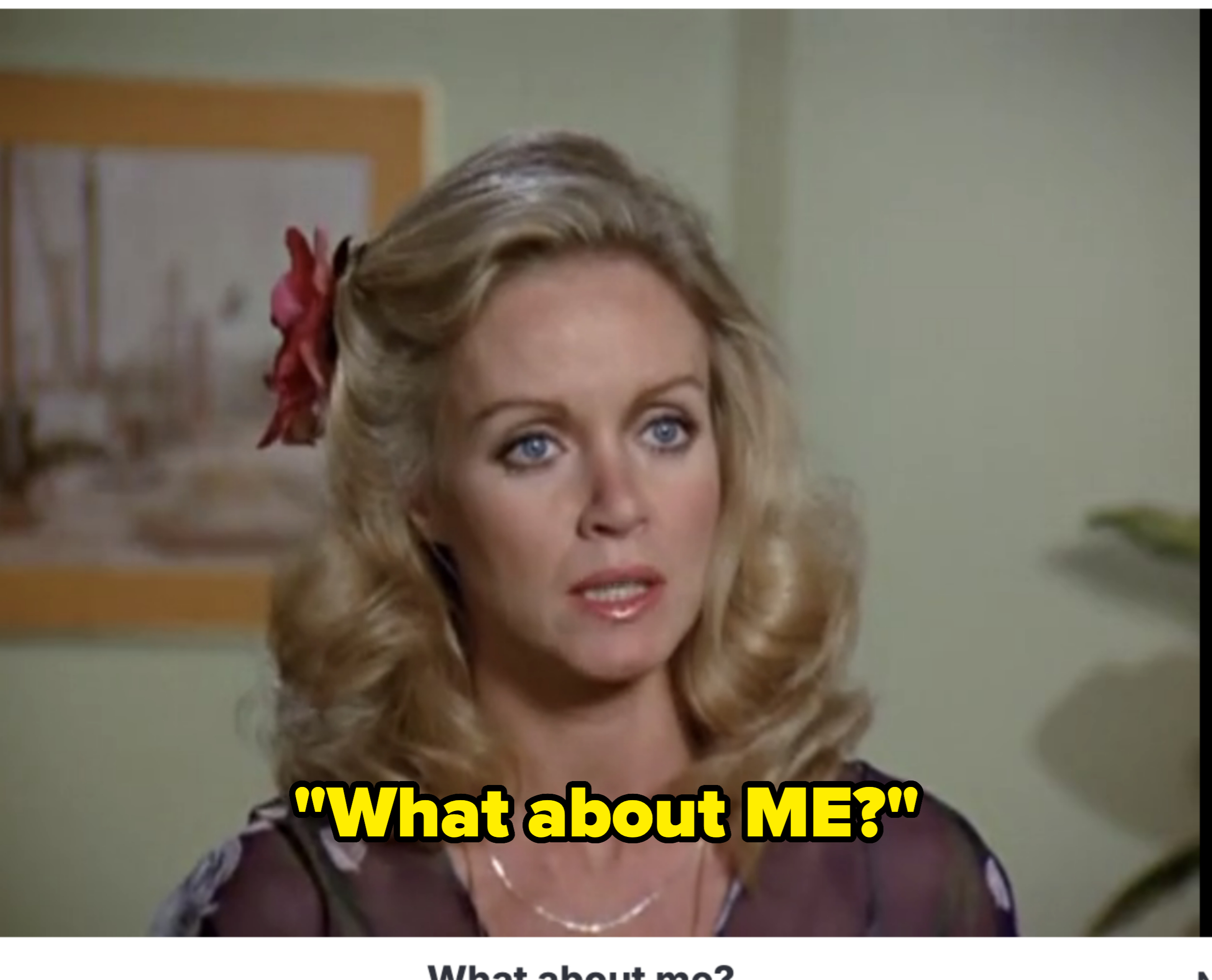 A woman with styled blonde hair and a floral accessory speaks with a concerned expression. Text reads: "What about me?"