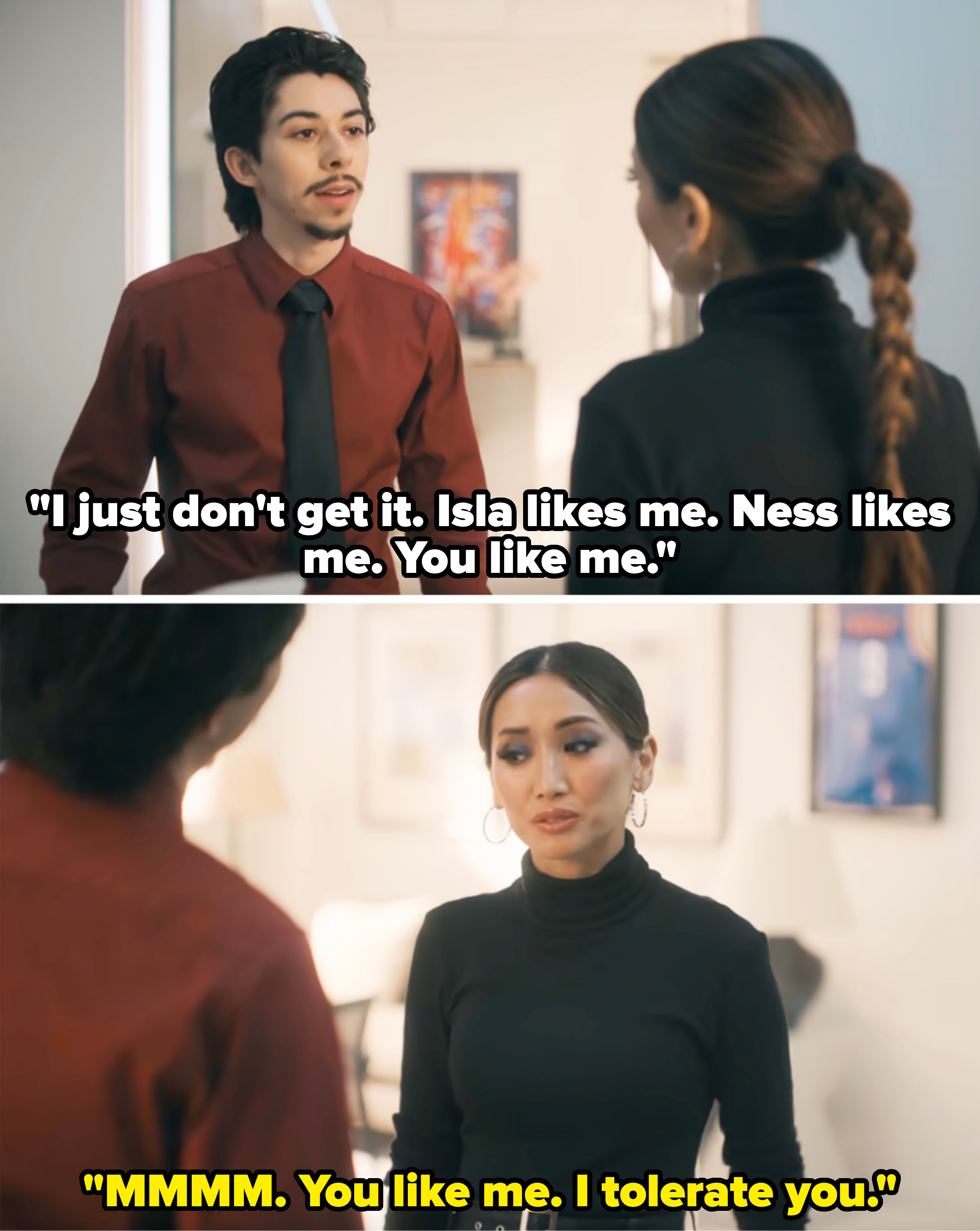 Two individuals conversing indoors; one wears a red shirt with a tie, the other in a black top with hoop earrings and a braid
