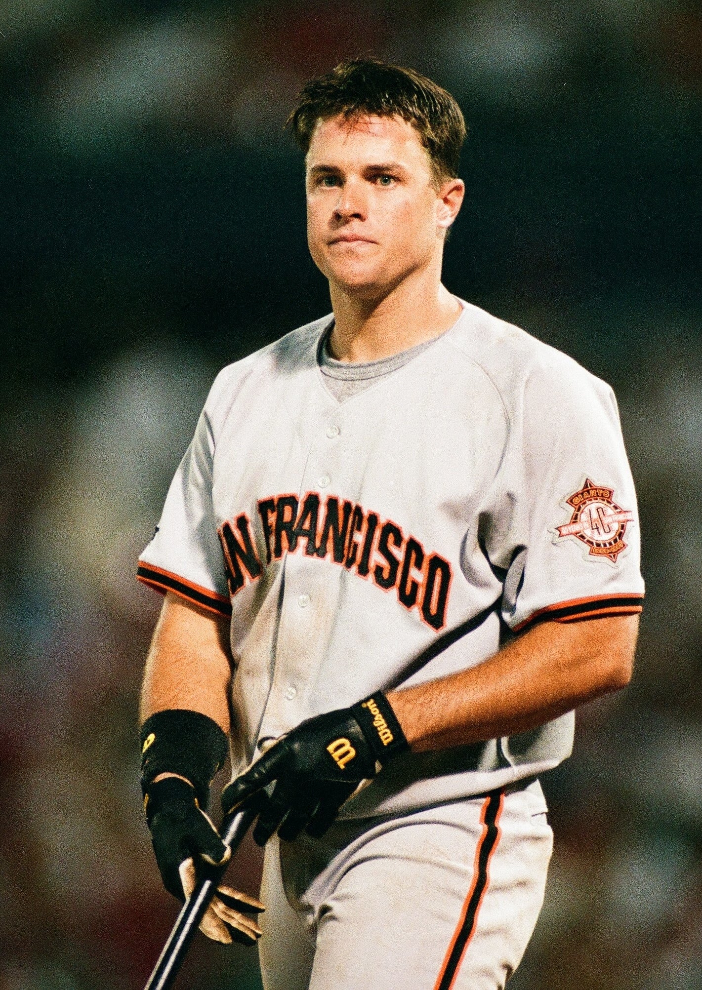 Baseball subordinate    successful  a San Francisco jersey holding a bat connected  the field, appearing contemplative during a game