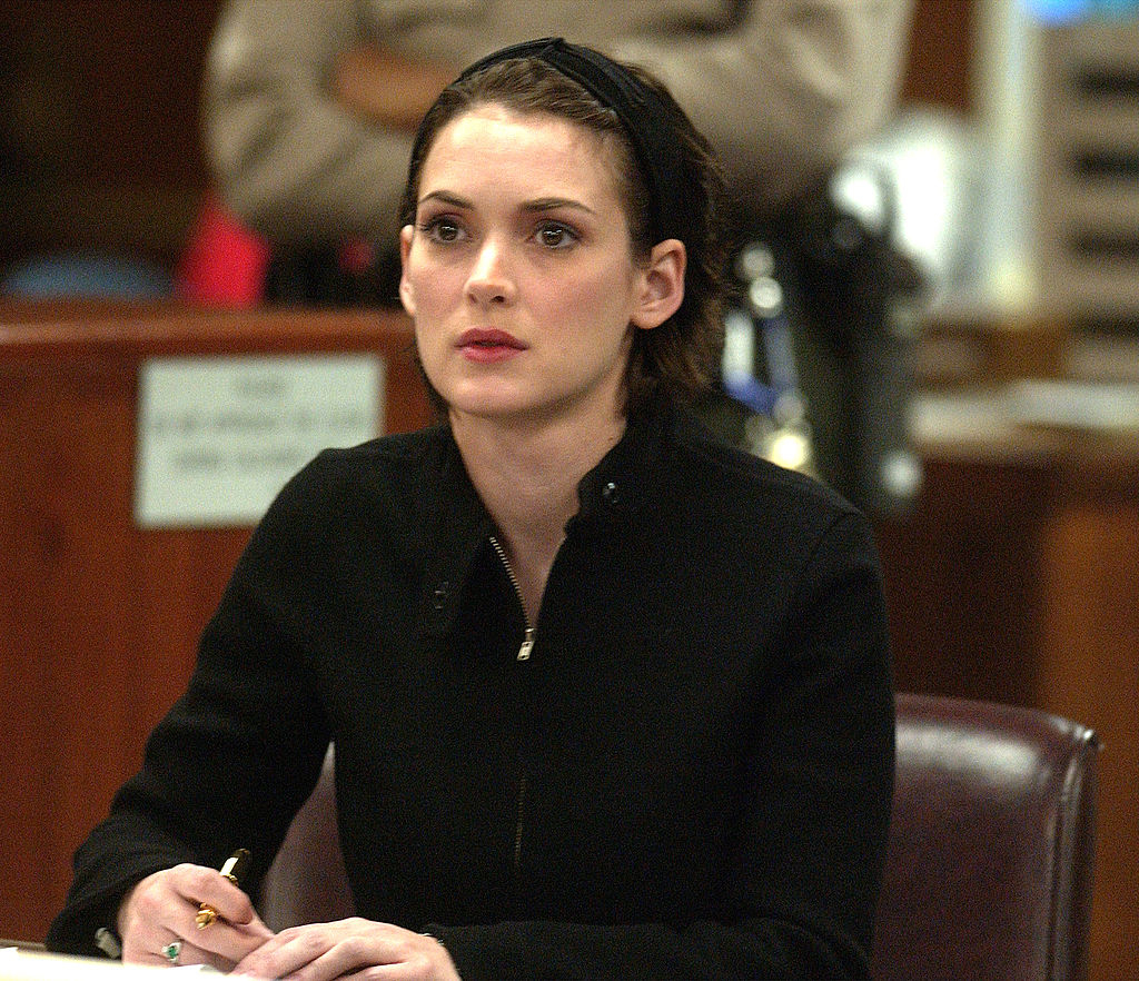 Person seated successful  a courtroom, wearing a achromatic  apical  with a headband, appearing attentive and focused