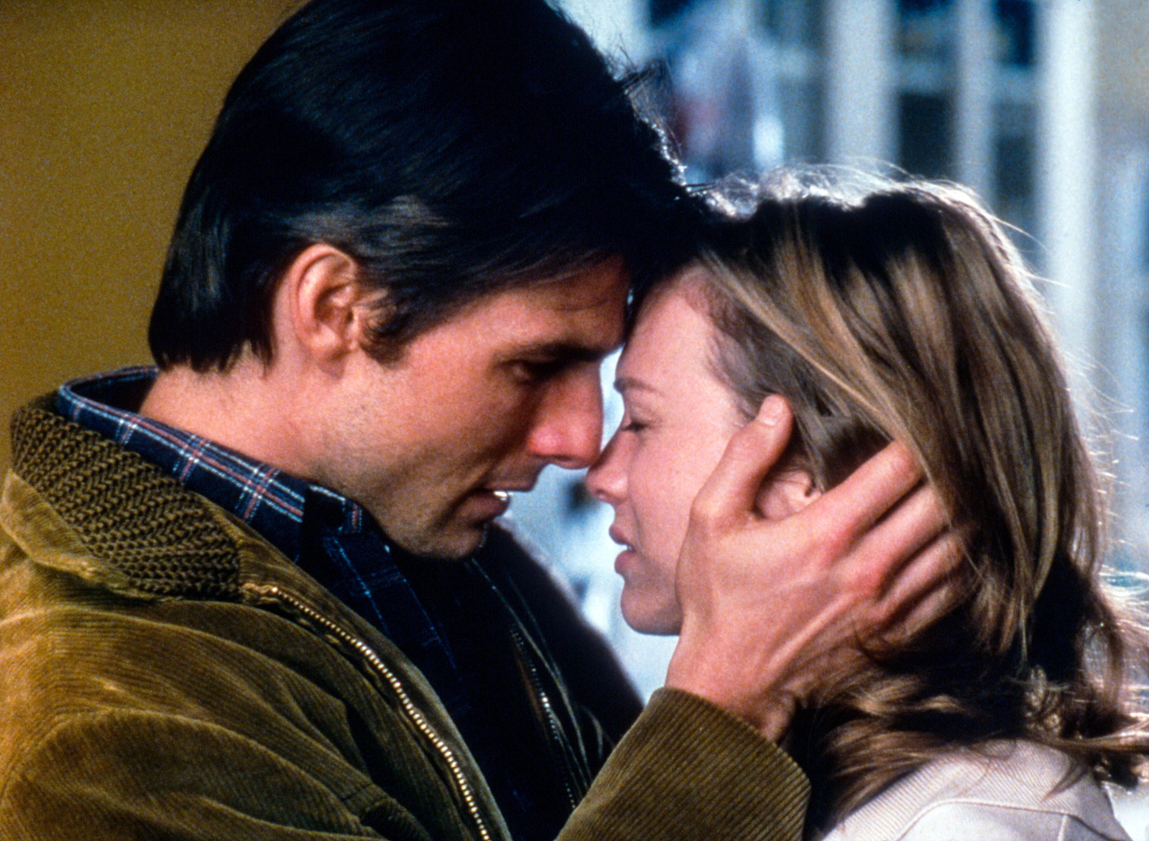 A close-up of a couple in an emotional embrace, with foreheads touching; both have their eyes closed, conveying a sense of intimacy and comfort