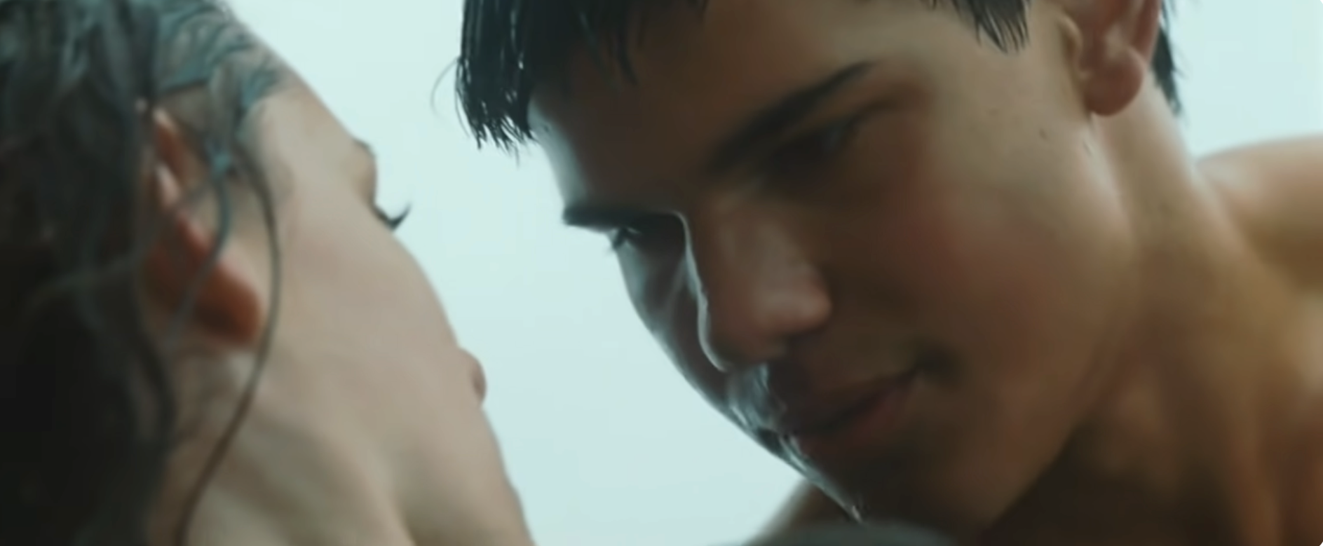 Two individuals share an intimate moment, facing each other closely