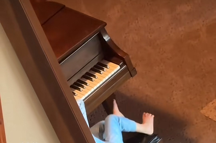 赤ん坊が姉妹を蹴れないと分かり、すぐにピアノで不満を表す様子。テキスト部分:不満を笑顔で表す。