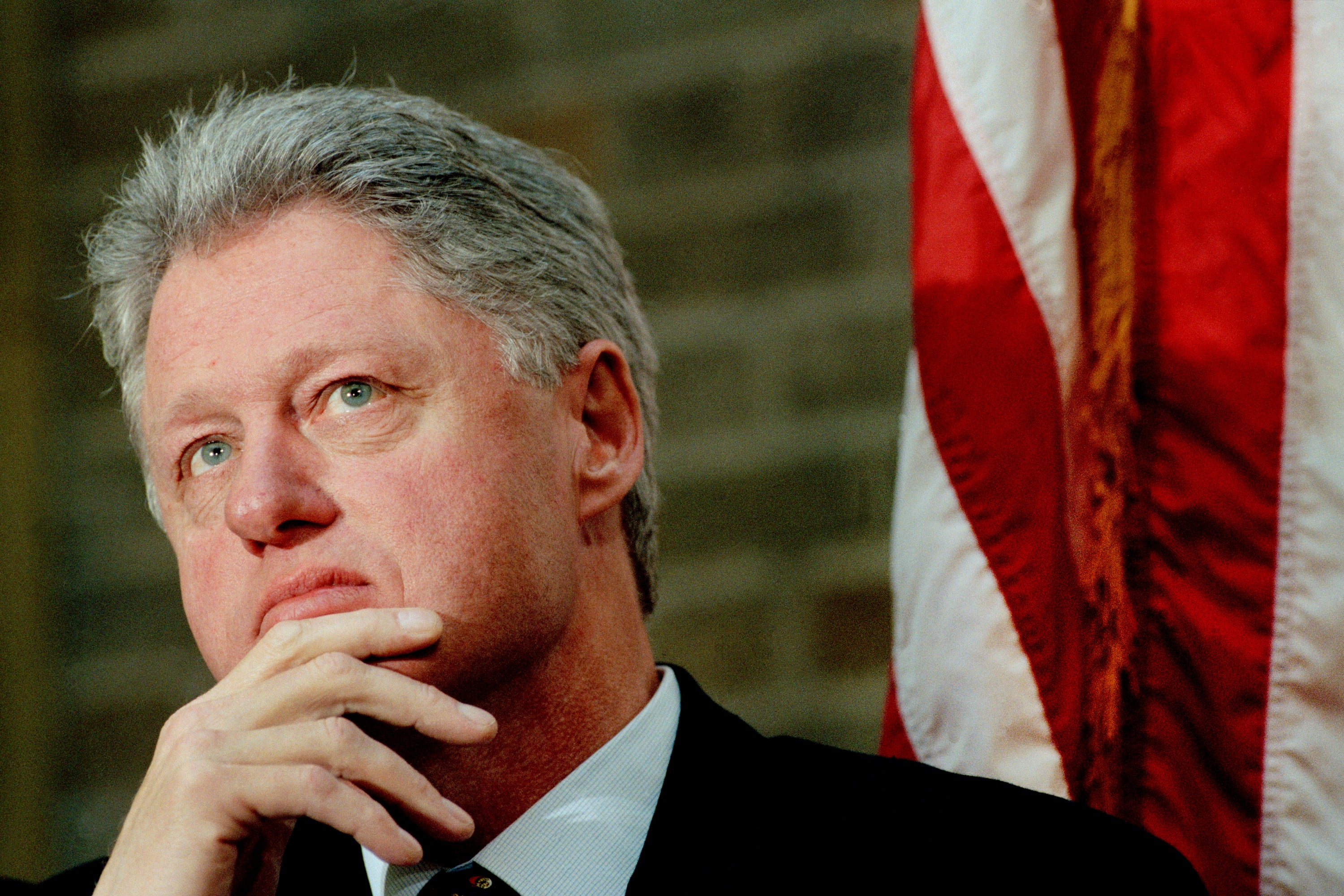 Bill Clinton in front of an American flag.