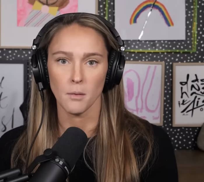 Kylie Kelce with headphones and a microphone, in front of colorful, abstract wall art