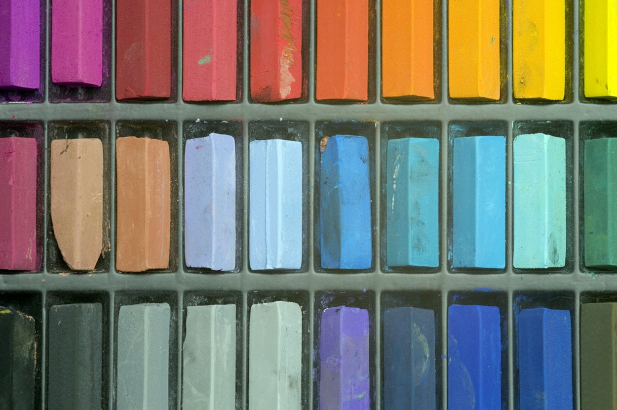 Assorted artist pastels arranged in a grid, showcasing a wide range of colors for artistic use