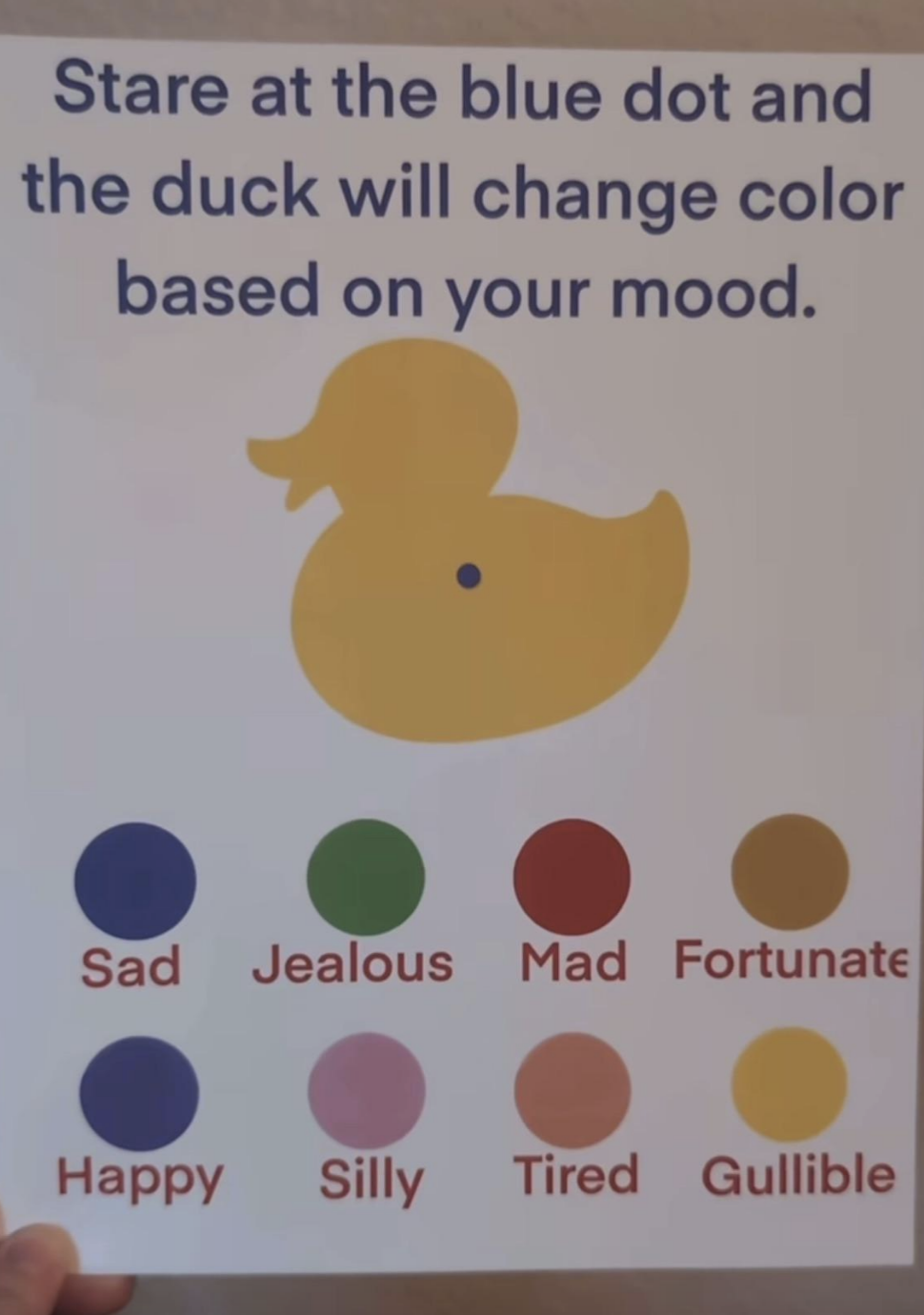 Sign explaining that staring at a blue dot on a duck will change the duck's color to reflect different moods: sad, jealous, mad, fortunate, etc