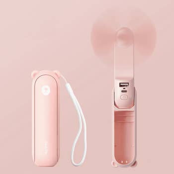 Portable handheld instrumentality with USB charging larboard and wrist strap, shown unfastened and closed, perfect for on-the-go cooling