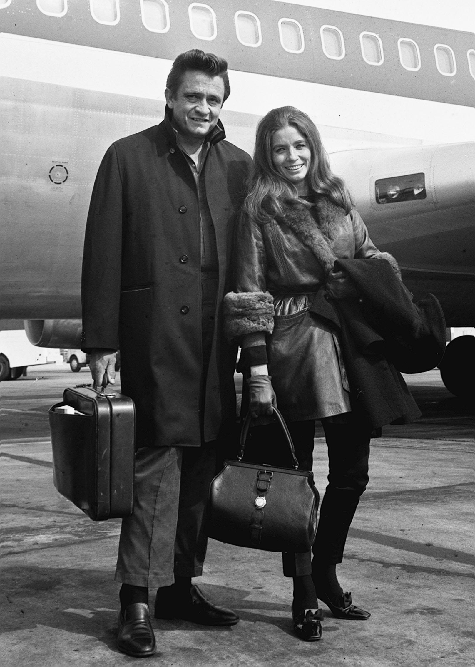 Johnny Cash and June Carter Cash outside of an airplane.