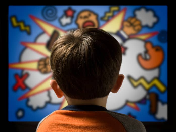 Child watching a cartoon on TV featuring vibrant comic-style characters in an action scene