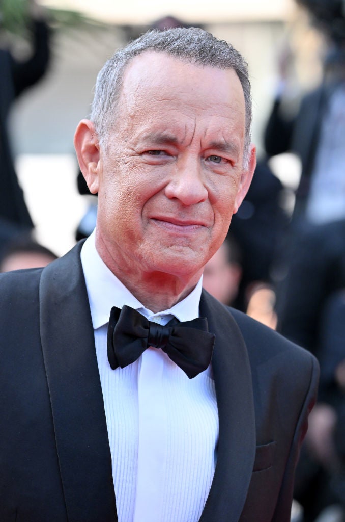 A person in a formal suit and bow tie is attending a red carpet event