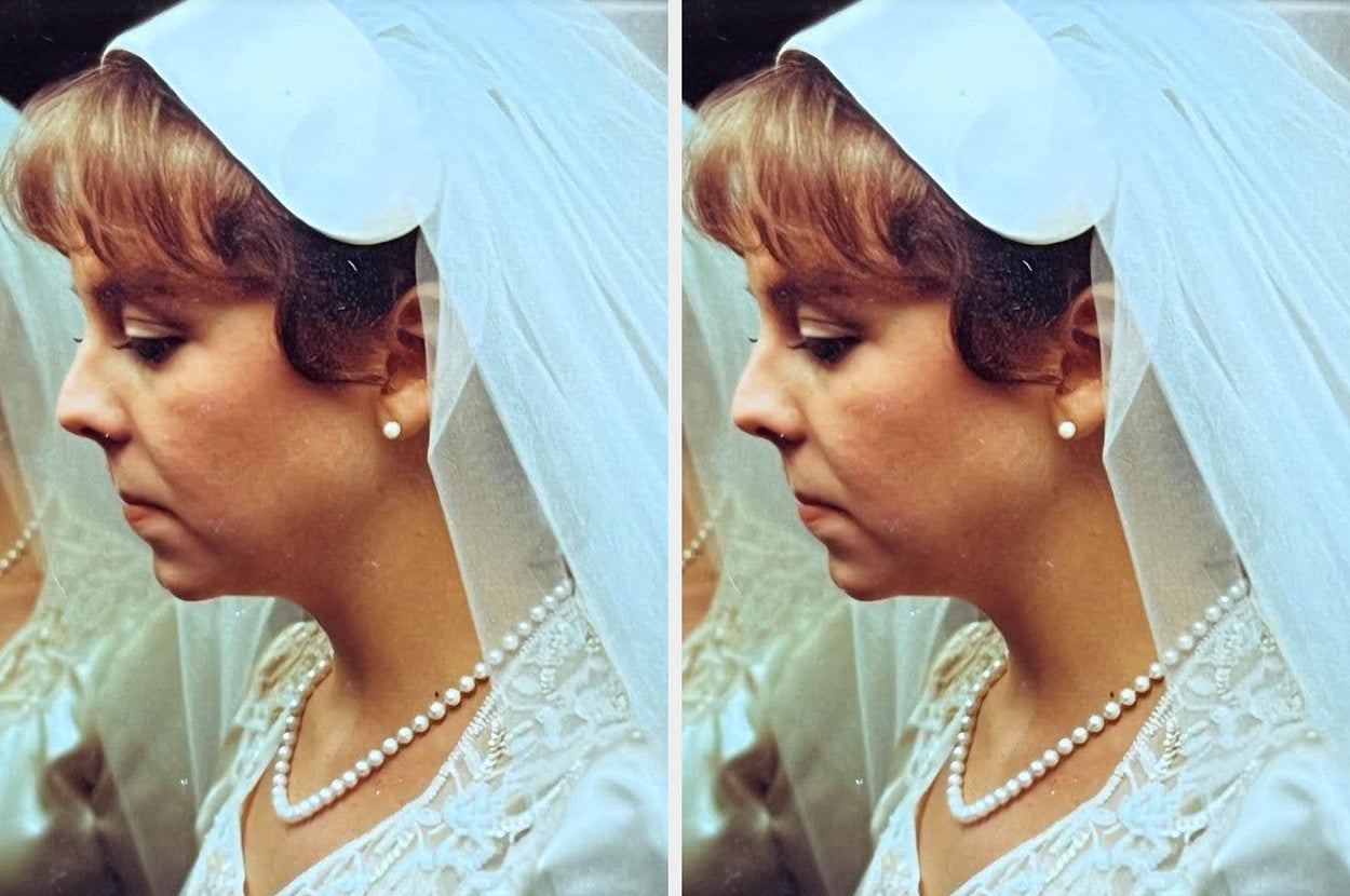 Bride in profile wearing a pearl necklace, lace-trimmed veil, and satin dress, stands in front of a mirrored reflection of herself
