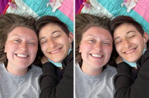 Two people lying close together, smiling with eyes closed, on a colorful blanket. The vibe is intimate and relaxed