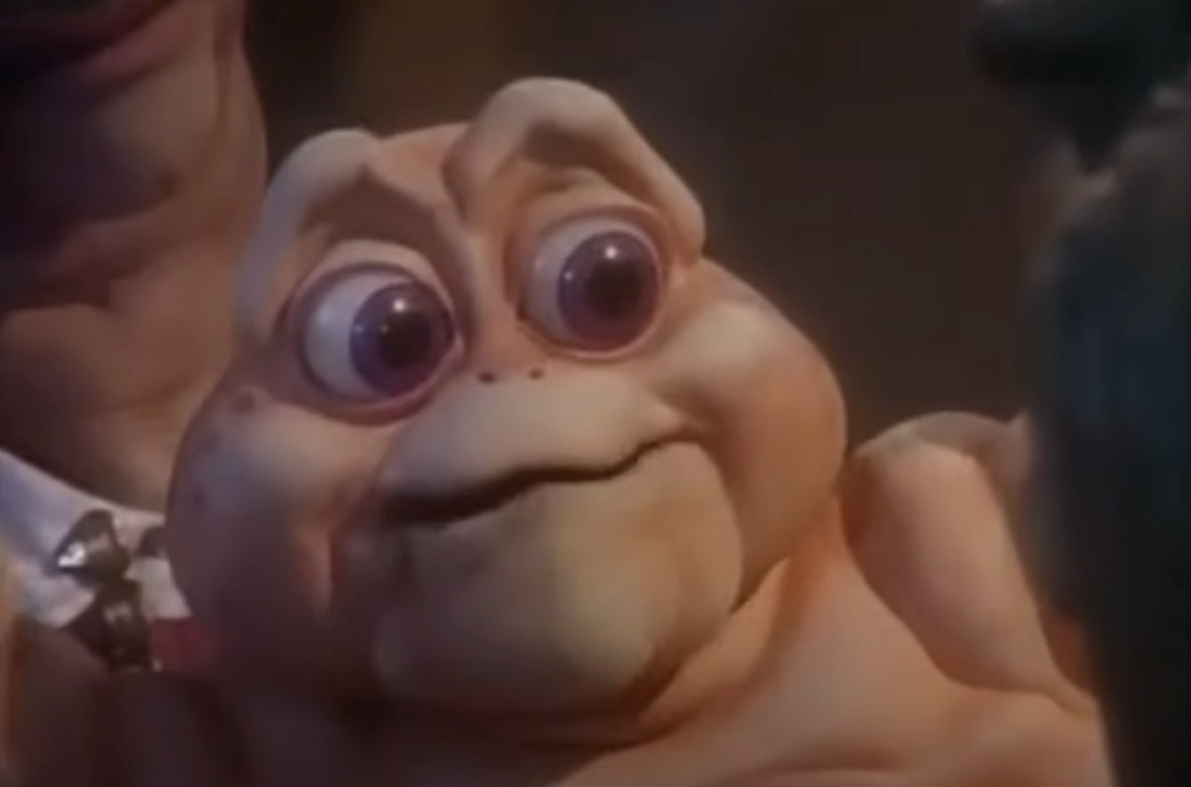 A puppet baby dinosaur with wide eyes and a big smile from a TV show