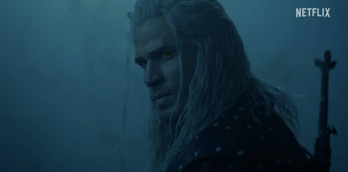 Character in medieval armor with long hair and glowing eyes looks intently. A sword is visible on their back. Netflix logo in corner