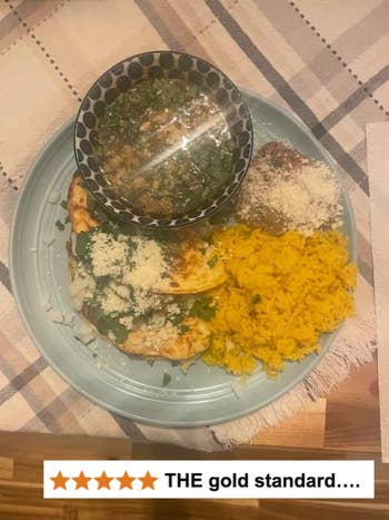 Plate of tacos with yellowish  atom   and a vessel  of greenish  dip, topped with cheese, connected  a table. Five-star standing  reads, 