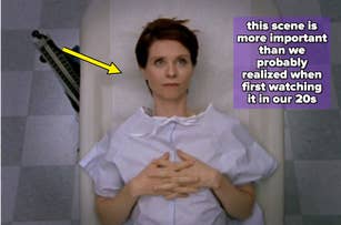 Person lying on a medical examination table, wearing a hospital gown, hands resting on their abdomen, with a thoughtful expression