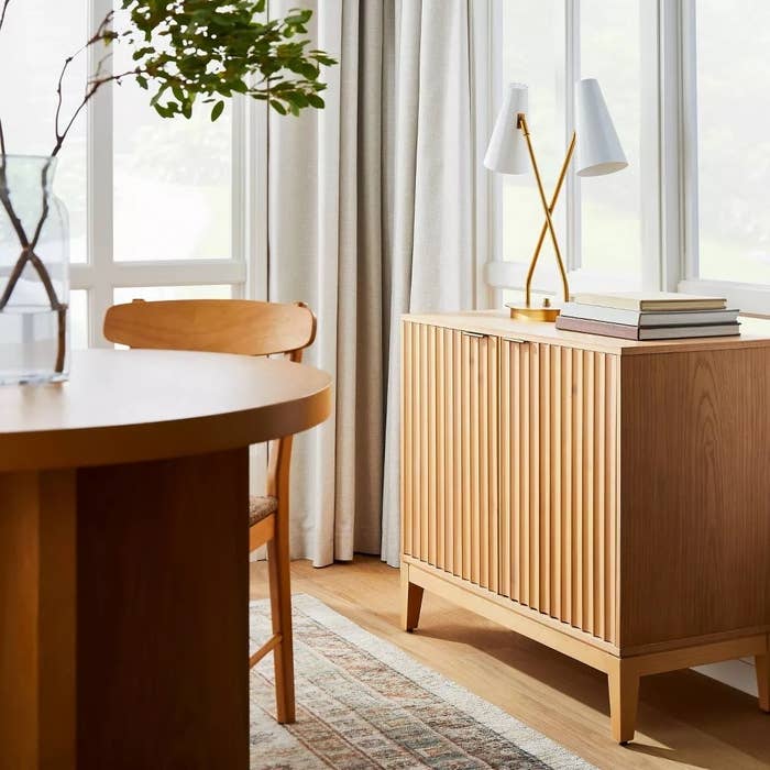 Stylish mid-century modern   eating  country  with woody  furniture, a sideboard, table, chair, and decorative lamp, perfect  for location  decor inspiration