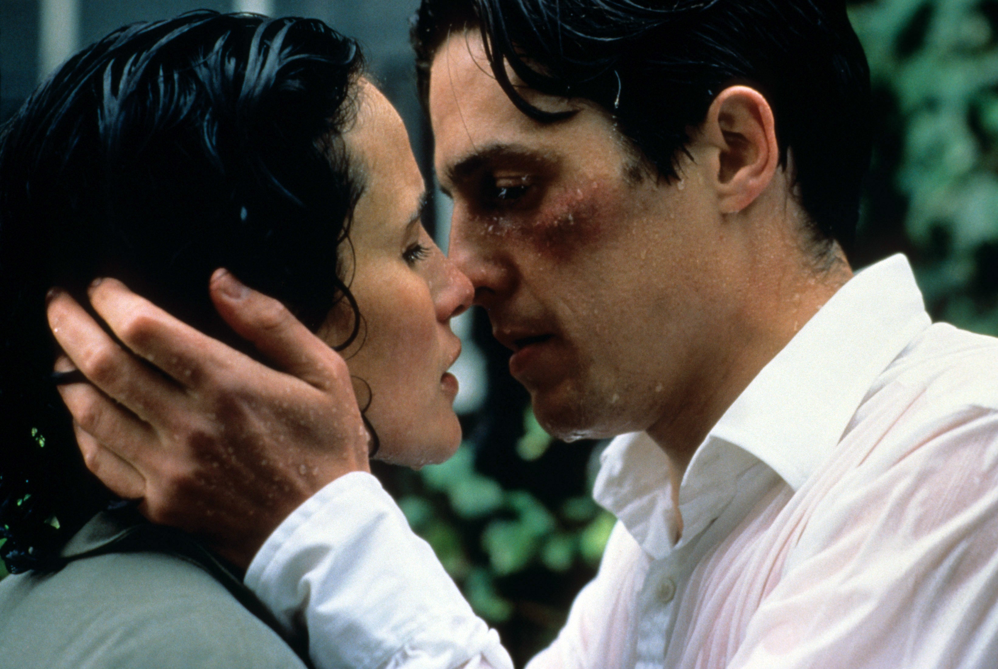 A couple faces each other closely in a romantic, intense moment, rain-soaked, with emotional expressions