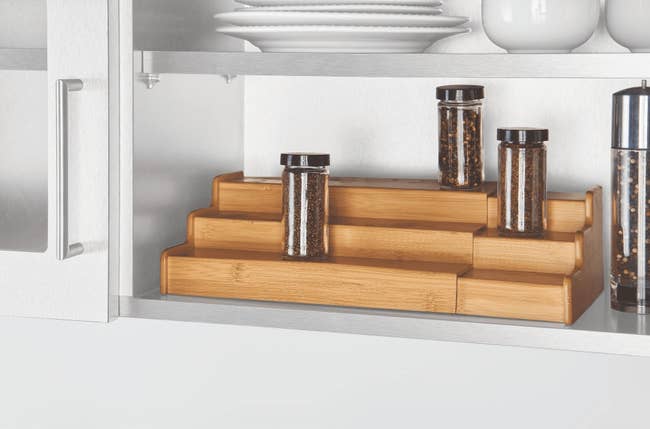 Tiered bamboo support  organizer successful  a room  furniture  with spice jars, adding abstraction  and casual  entree  for spices