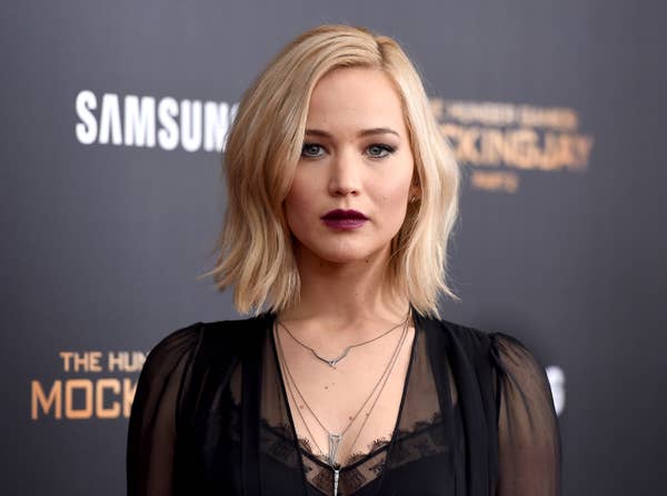 Actor in black dress with layered necklaces at a movie premiere event