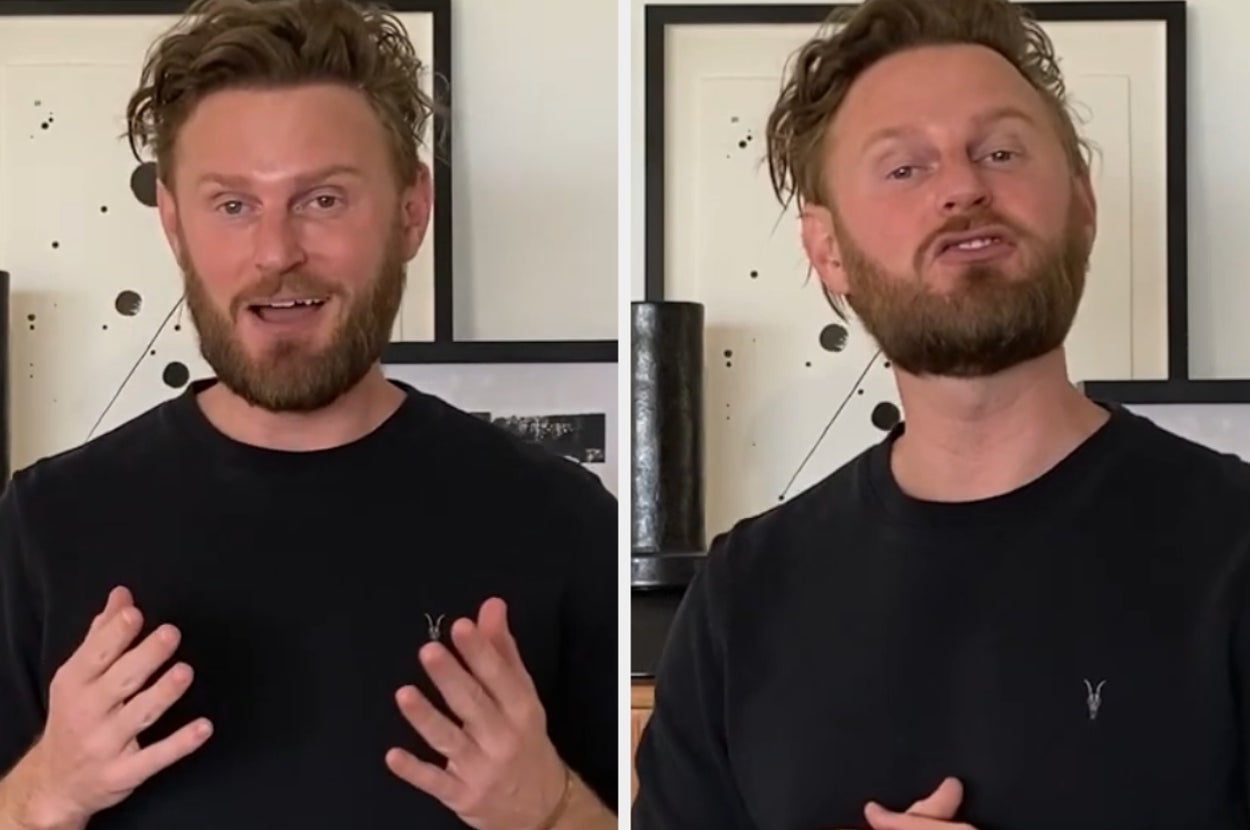 Person wearing a casual dark t-shirt, gesturing with hands, in front of minimalist artwork