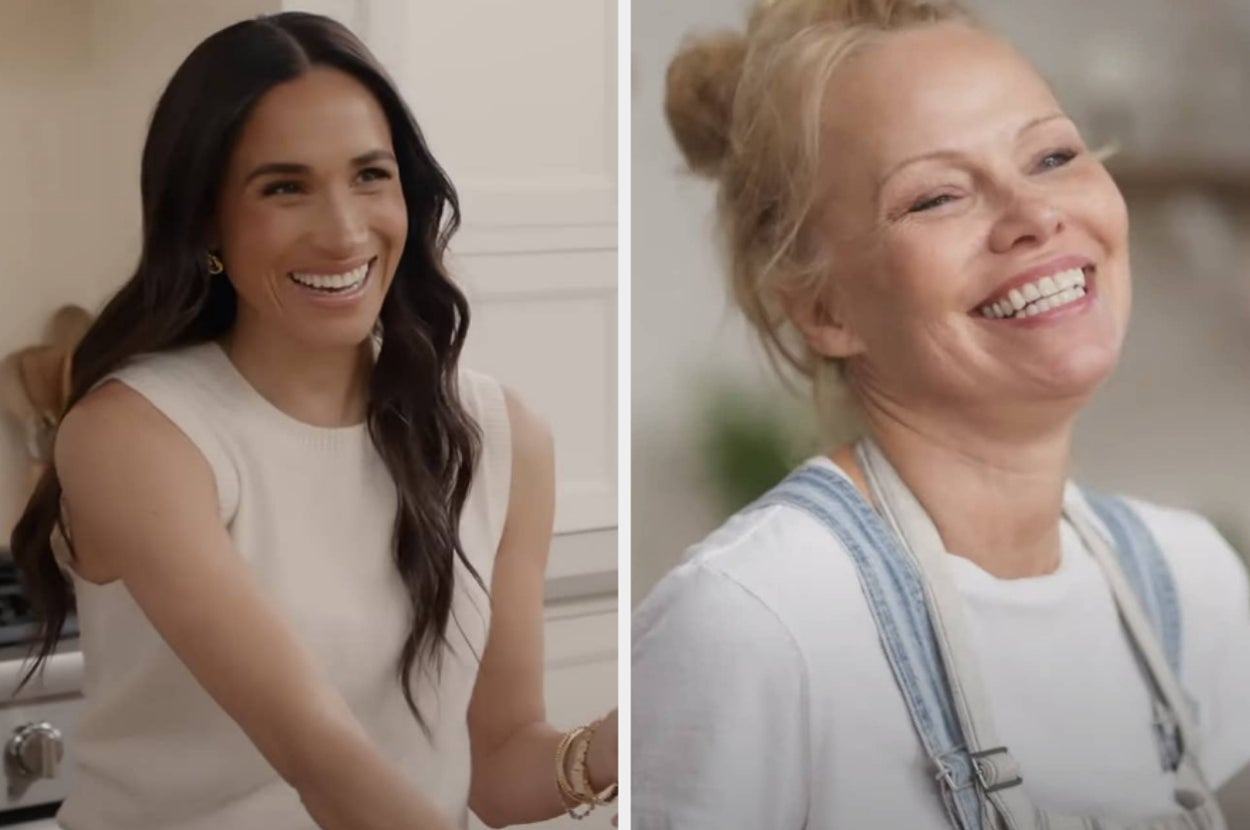 Two women smiling; one with long hair in a sleeveless top, the other with tied-back hair, wearing a t-shirt and overalls
