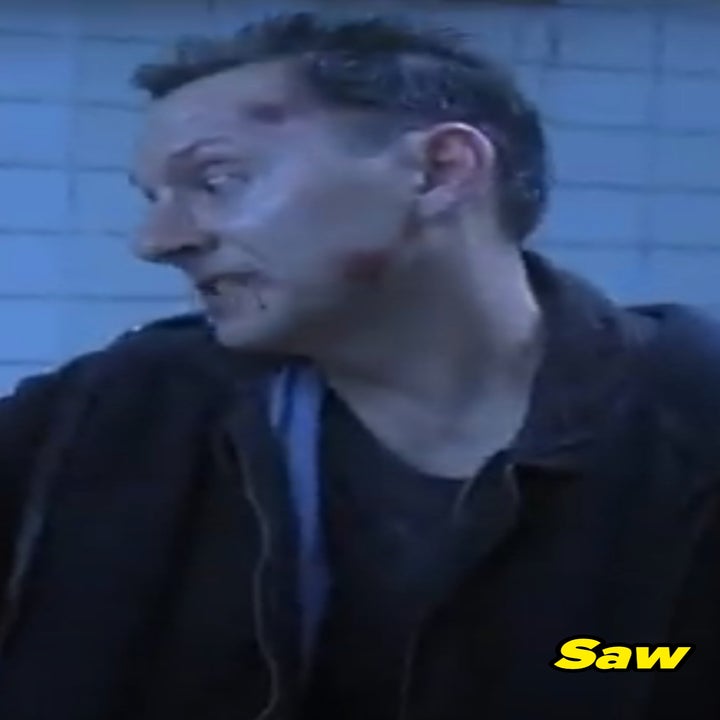 Michael Emerson as Zep in Saw in a dimly lit room, looking concerned. He is  wearing casual, slightly disheveled clothing