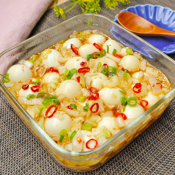 うずらの卵とタマネギ、ネギ、赤唐辛子をトッピングした料理の盛り付け。