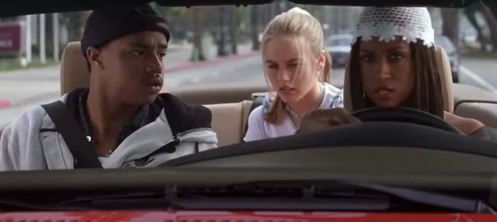 Three people are in a car; the driver concentrates as passengers look concerned