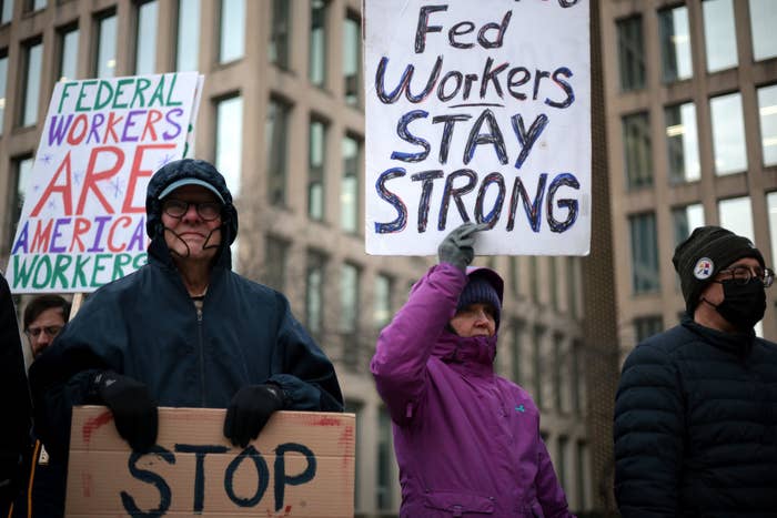 People hold signs reading 