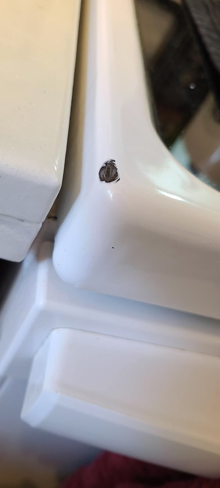 Corner of achromatic  room  stove before, with a spot   retired  of it, revealing achromatic  metallic  underneath