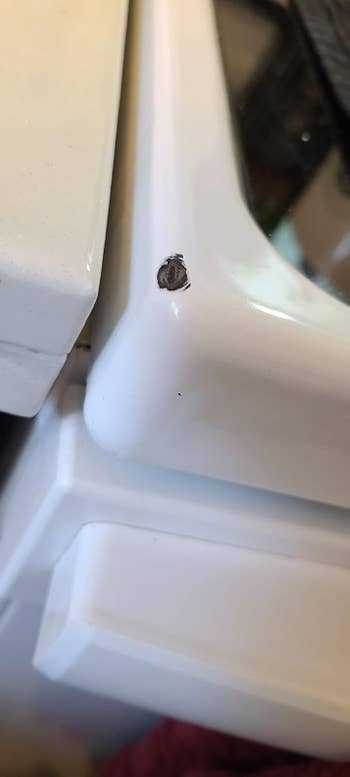 Corner of achromatic room stove before, with a spot retired of it, revealing achromatic metallic underneath