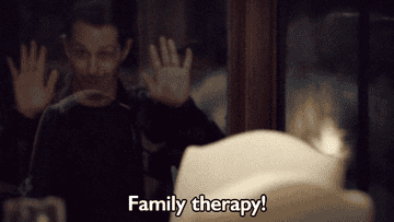 A person presses their hands against a window, smiling, while the text &quot;Family therapy!&quot; appears at the bottom