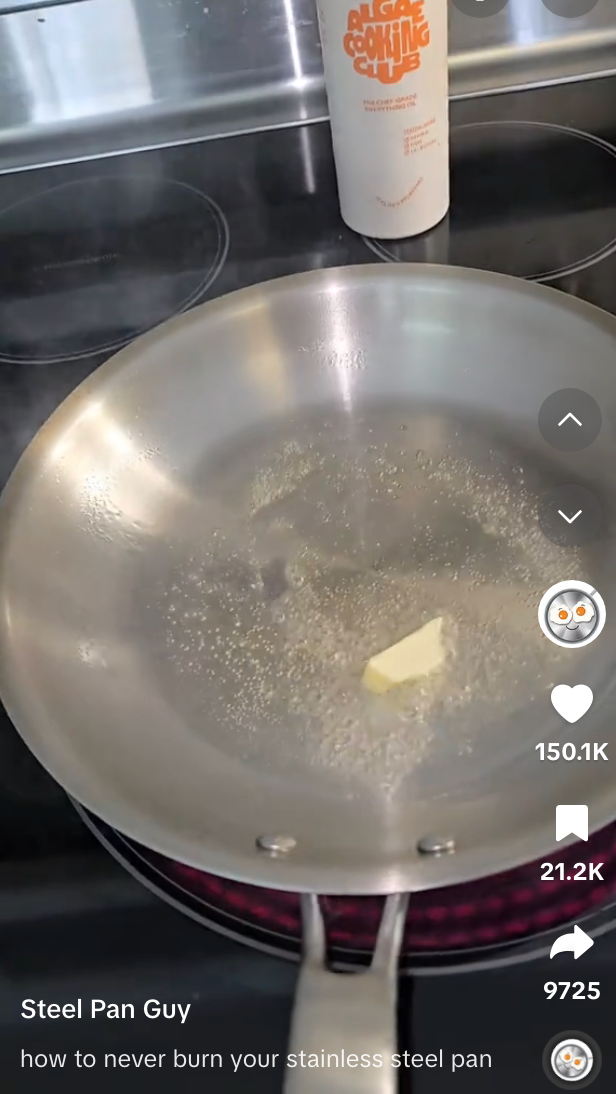 Butter melting in a stainless steel pan on a stovetop with a bottle in the background. Text overlay: &quot;how to never burn your stainless steel pan.&quot;
