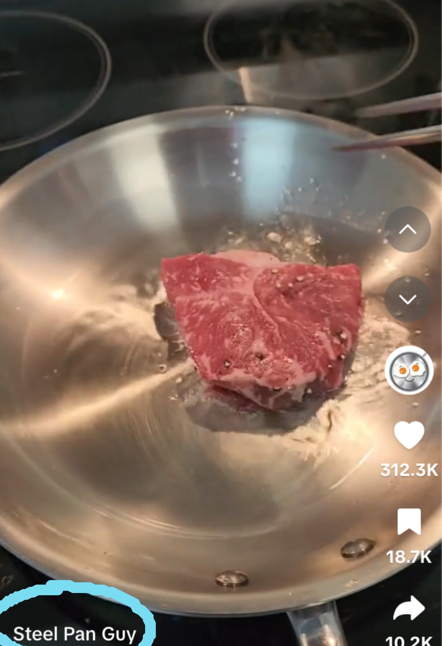 Raw steak sizzling in a stainless steel pan on a stovetop. Text asks about the debate between stainless steel and cast iron for cooking steak