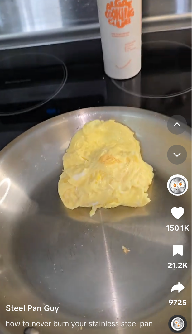 An omelette in a stainless steel pan with a cup in the background, showing a video on keeping the pan non-stick