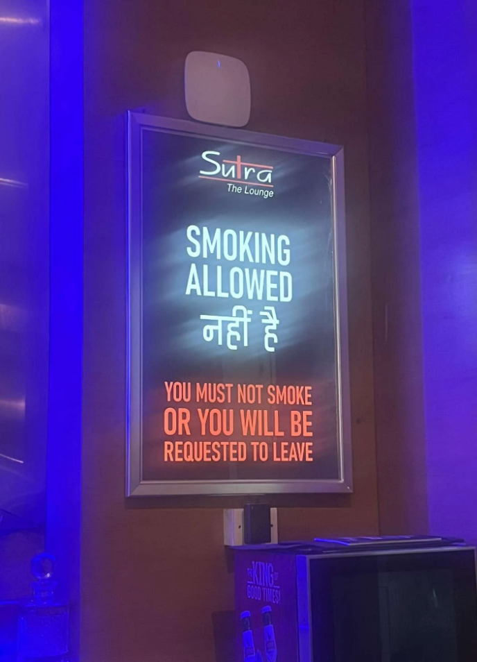 Sign reading &quot;Smoking allowed नहीं है. You must not smoke or you will be requested to leave&quot; at Sutra The Lounge