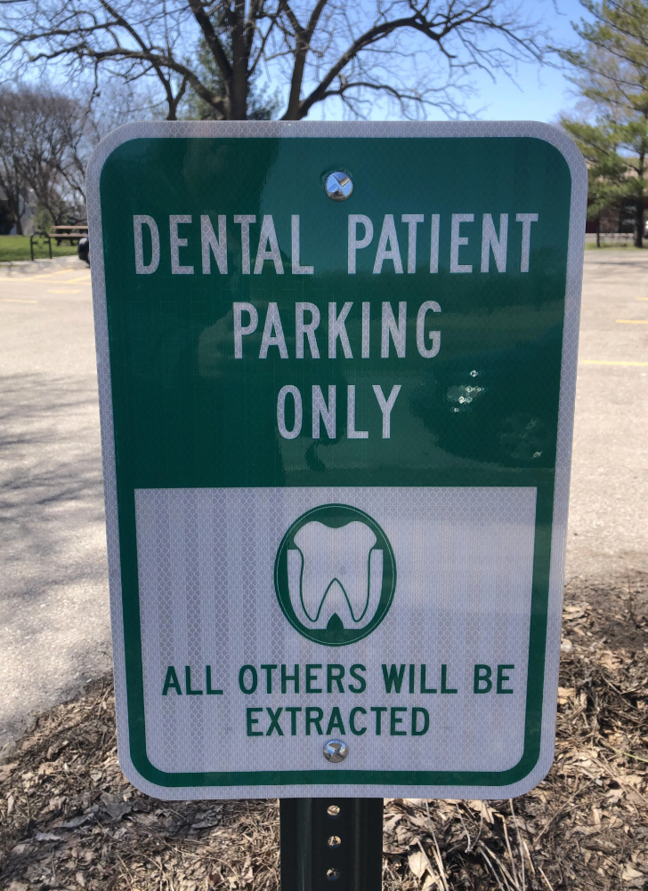 Sign reads: &quot;Dental Patient Parking Only. All Others Will Be Extracted&quot; with a tooth icon
