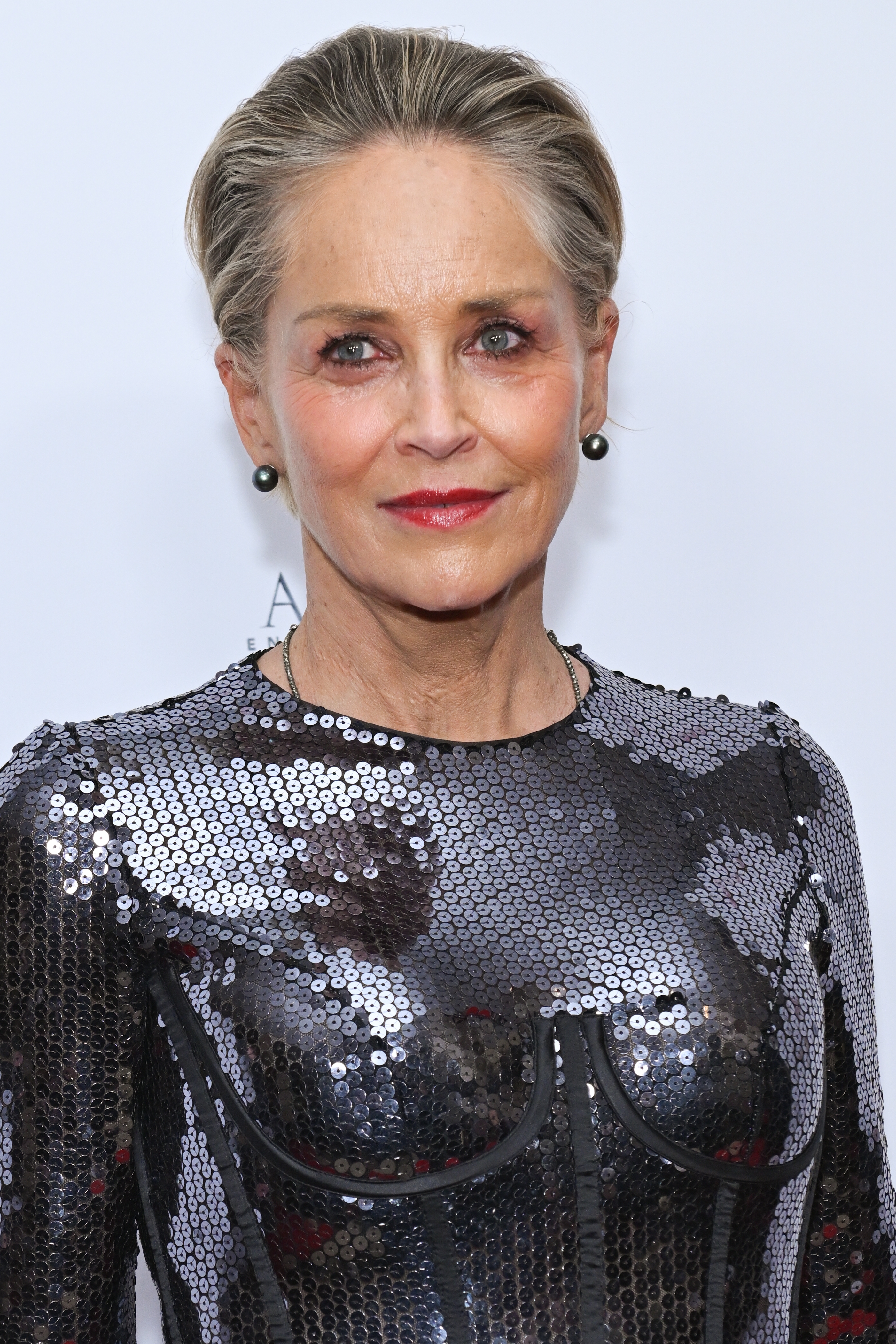 Sharon Stone in a sequined dress with structured detailing on the red carpet