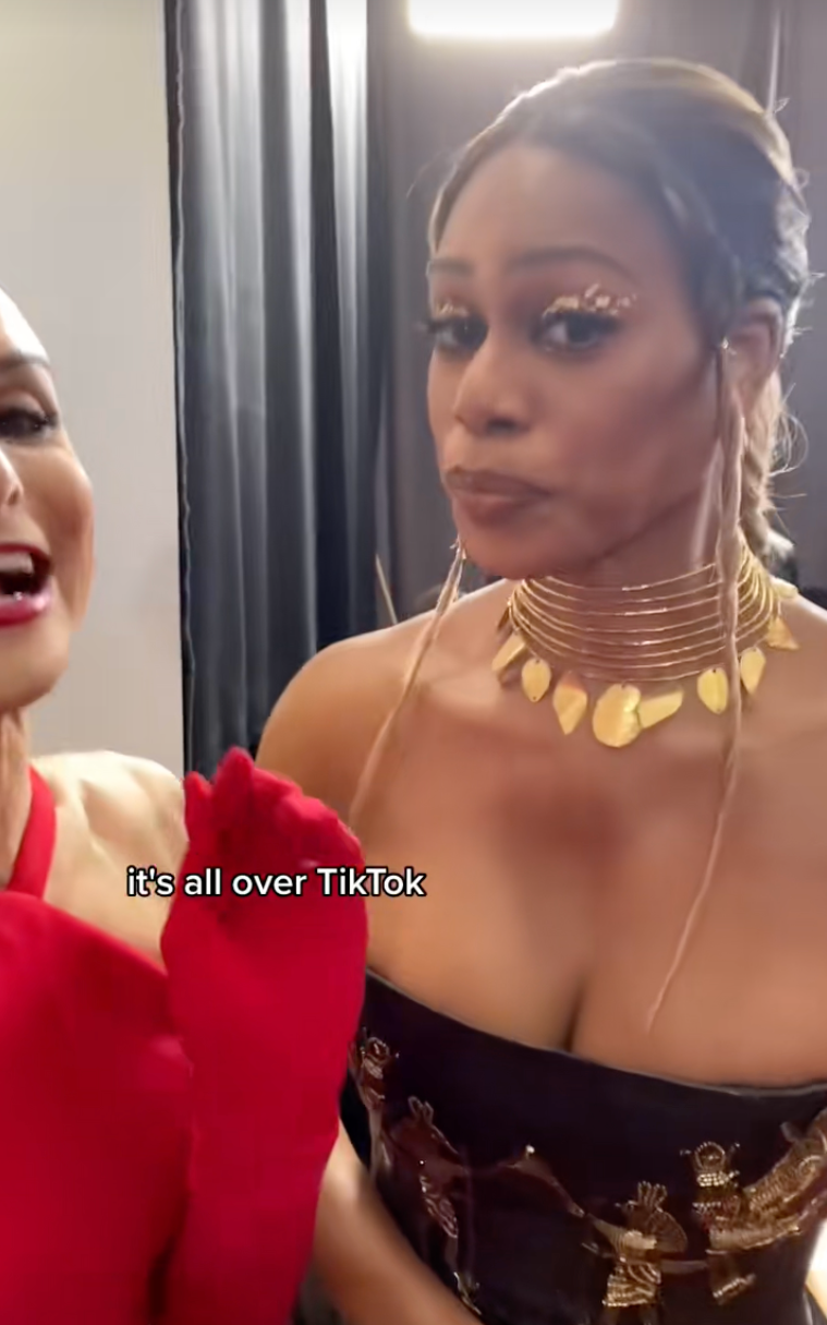 Dylan Mulvaney laughs energetically while talking to Laverne Cox on the red carpet