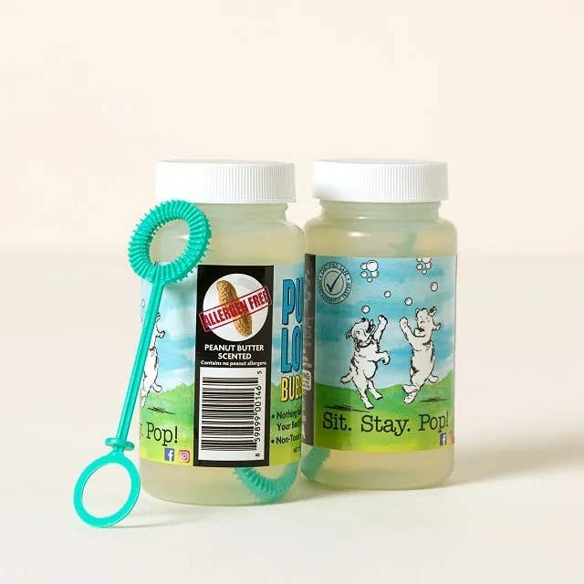 Two bottles of peanut butter-scented canine  bubbles with a bubble wand included, labeled 