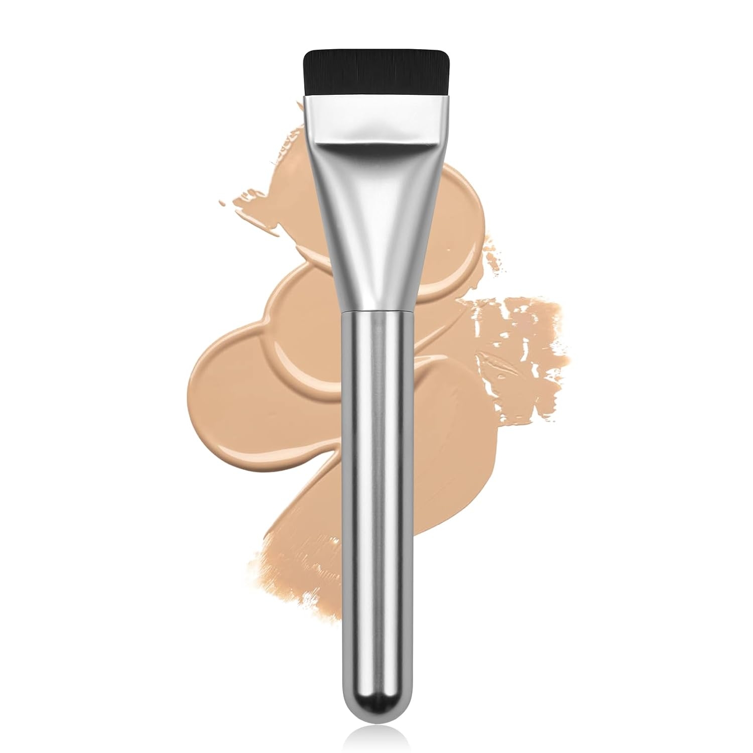 Makeup brush with a metallic handle against a background of beige foundation swatches