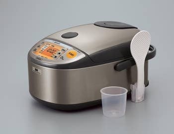Rice cooker with digital display, spoon, and measuring cup