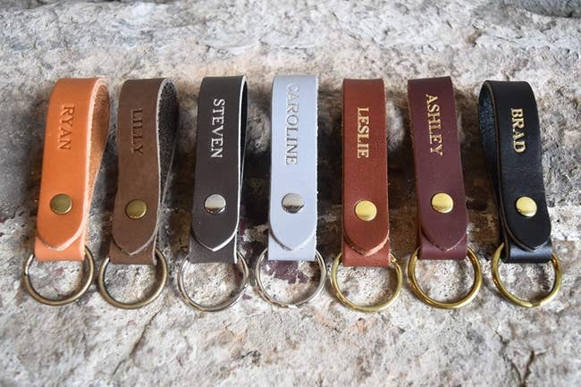 Leather keychains with metal rings, each embossed with different names: Ryan, Lilly, Steven, Caroline, Leslie, Ashley, Brad