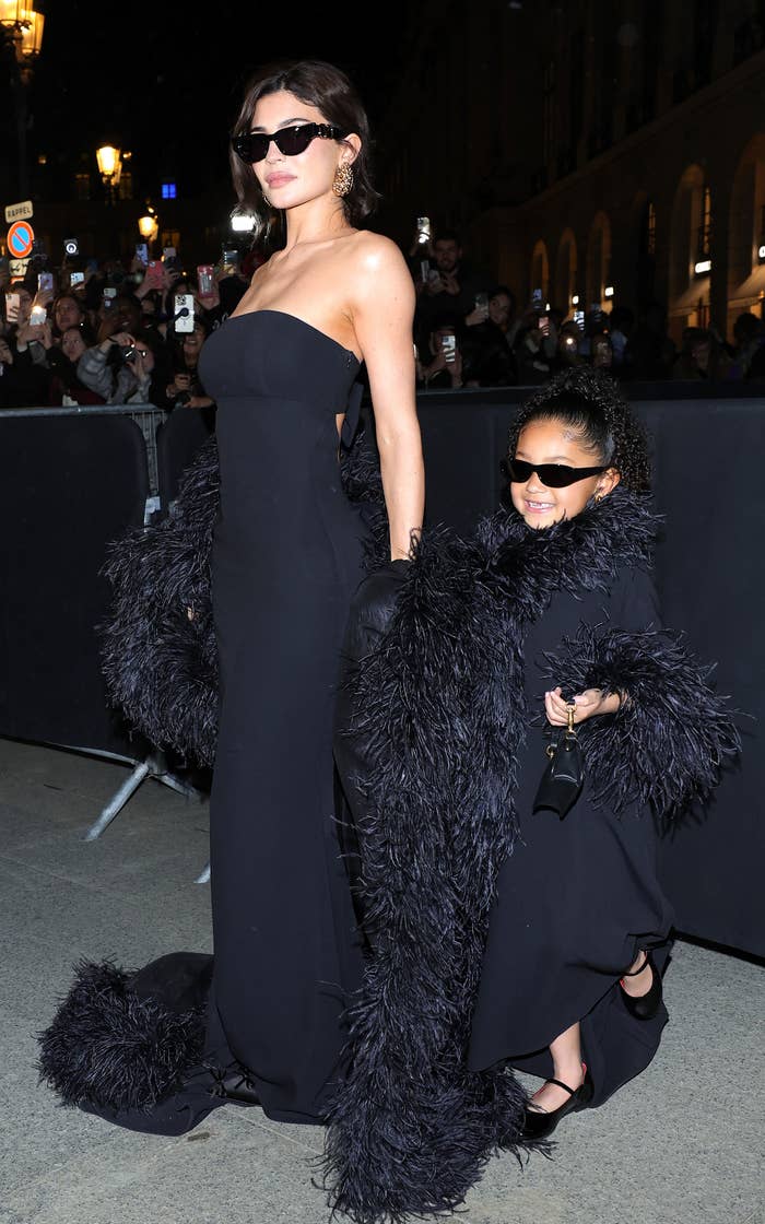Kylie Jenner and Stormi Webster wearing elegant, matching black gowns at an event