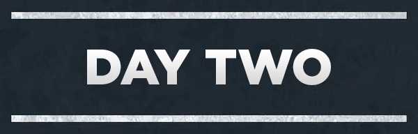 Sign with bold text reads "DAY TWO" between two horizontal lines